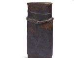 a brown vase that is sitting on a white surface