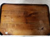 a wooden tray with a handle on it on a tile floor