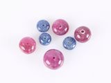 six pink, blue and purple beads on a white background