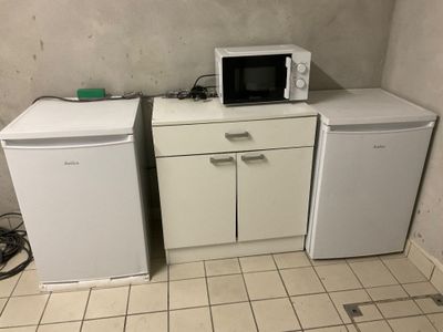 deux micro-ondes et un réfrigérateur dans une petite pièce