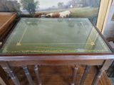 a table with a glass top and a painting on the wall behind it