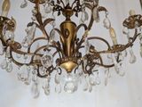 a gold chandelier with crystal beads hanging from the ceiling