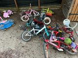 a pile of children ' s bikes and tricycles on the ground
