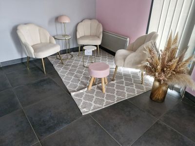 three chairs and a table in a room with a pink wall