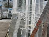 a pile of windows sitting on a pallet in a parking lot