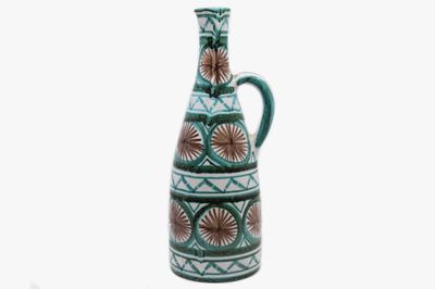 un vase vert orné d'un motif sur fond blanc