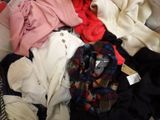 a pile of clothes sitting on top of a bed