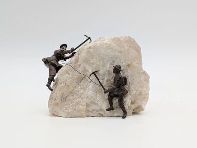 statue représentant deux hommes sur un rocher, tenant une épée et une lance
