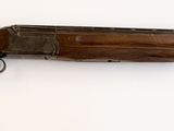un fusil accroché au mur d'une pièce sur fond blanc
