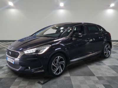 a black car is parked in a large room with a checkered floor