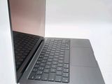 a silver laptop with a black keyboard on a white surface