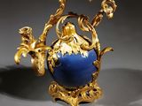a gold and blue vase sitting on a table
