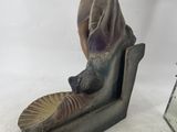 a figurine of a woman sitting on a chair