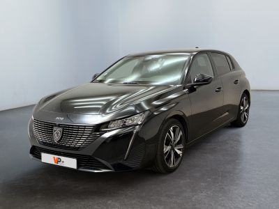 La voiture noire est garée dans une grande pièce au sol noir.