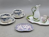un pichet blanc et quatre tasses et soucoupes bleues et blanches posés sur un plateau