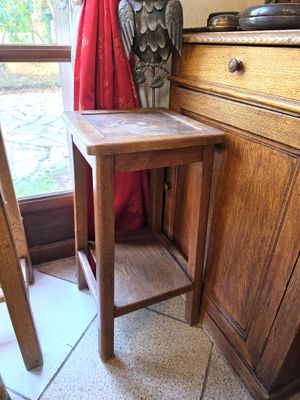 une petite table en bois sur laquelle trône une statuette d'oiseau