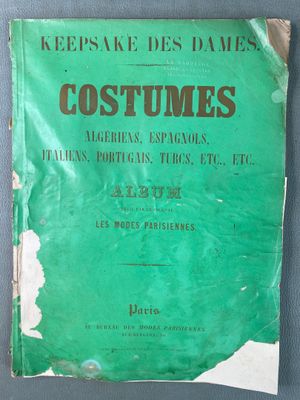un vieux livre à la couverture verte posé sur une table