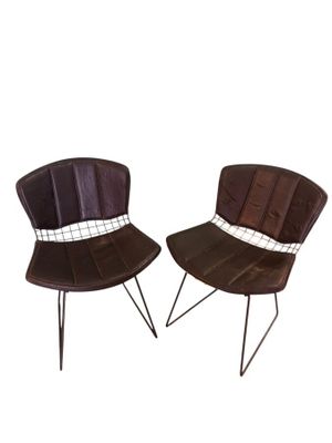 une paire de fauteuils en cuir marron avec des pieds et des dossiers en métal