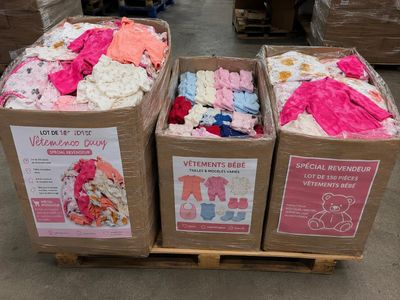 boxes of baby clothes are stacked on a pallet in a warehouse