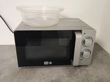 a microwave with a bowl on top of it