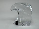 a clear glass sculpture of a bird on a white surface