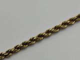 a close up of a gold chain on a white surface
