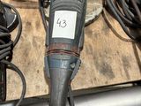 une photo représentant une perceuse et d'autres outils posés sur un établi