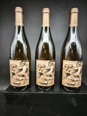 trois bouteilles de vin sont posées sur un bloc noir