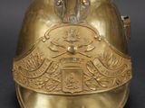 a gold helmet with a crown on it on a black background
