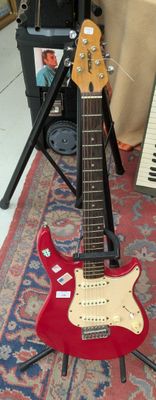une guitare posée sur un support dans une pièce