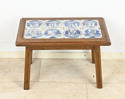 une petite table en bois sur laquelle est posé un carreau bleu et blanc