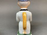 a figurine of a man with a hat on his head