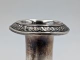a silver vase sitting on a table with a white background