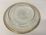 a glass plate with a gold rim on a white table
