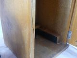 a wooden cabinet with a door open on a white sheet