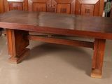 a large wooden table in a room with wooden chairs