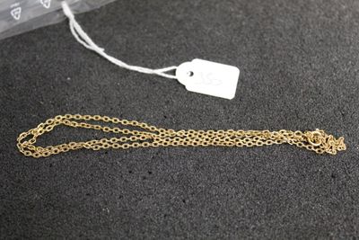 gros plan sur une chaîne en or à laquelle est attachée une étiquette