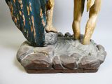 une statue représentant un homme et une femme debout sur un rocher