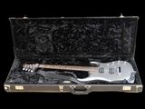 une guitare rangée dans un étui, sur fond noir