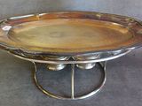 un plat ancien en argent posé sur un socle, sur une surface grise