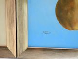 two paintings of an apple and a pear on the wall