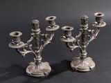 pair of antique silver plated candelabs on a black background