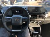 someone is sitting in the driver ' s seat of a car with their feet on the steering wheel