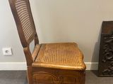 a wooden chair with a wicker seat in the corner of a room