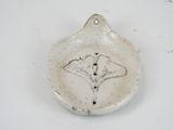 a small ceramic dish with a ginknife design on it