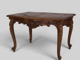 an old wooden table with carved legs and a wooden top