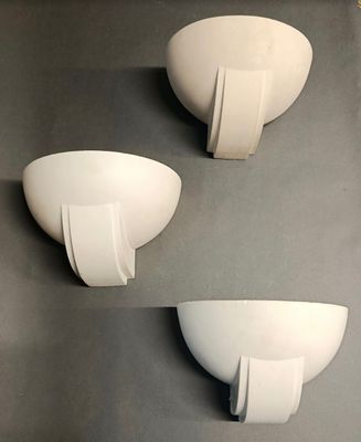 trois bols blancs sont posés sur une surface grise avec un fond noir