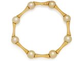 un bracelet en or orné de perles sur fond blanc