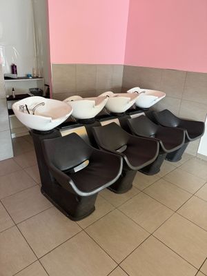 une rangée de lavabos dans des toilettes publiques aux murs roses