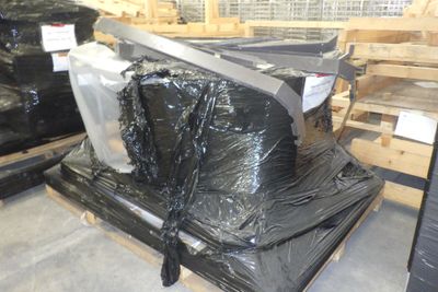 une pile de sacs en plastique noirs posée sur une palette dans un entrepôt